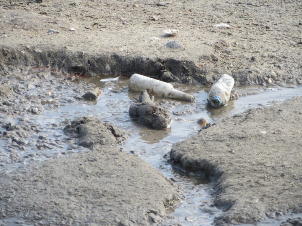 Global plastic recycling problems - plastic bottles on dry lake bed